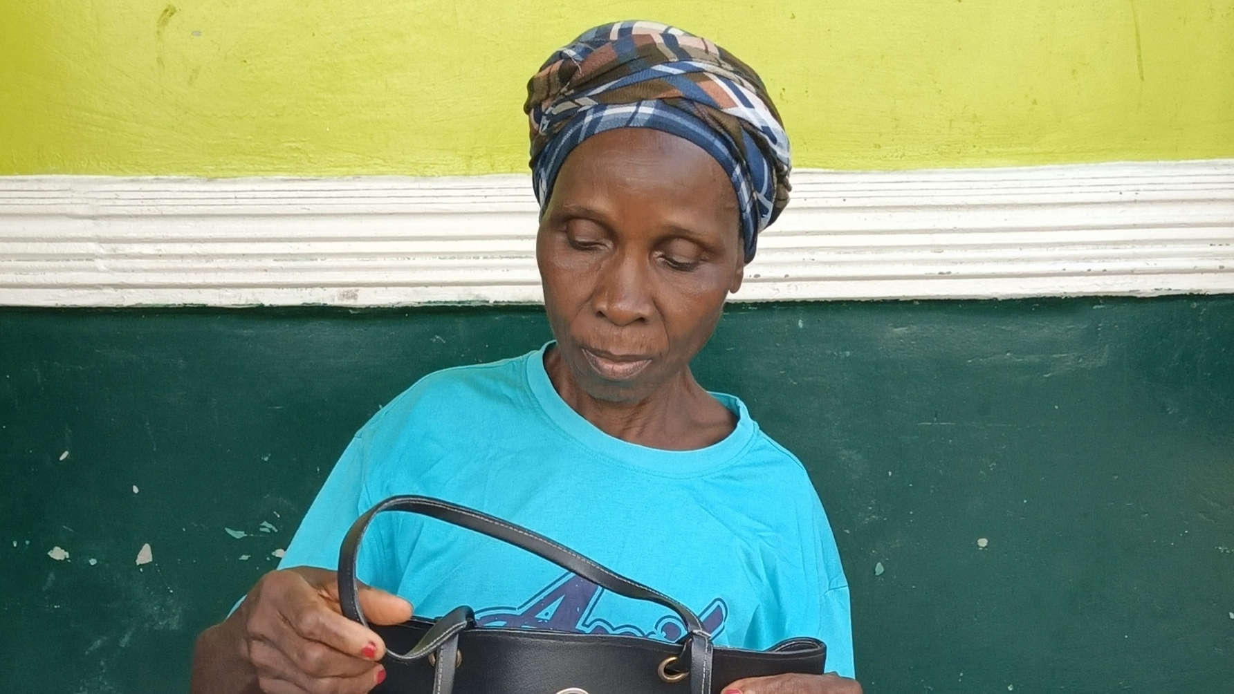 Nathan R. Watalah's mother in Liberia wearing blue shirt and traditional headwrap